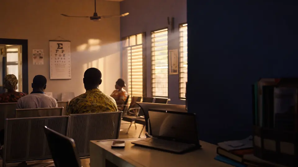 A bright clinic waiting room in the morning, chairs in rows and light through the louvres