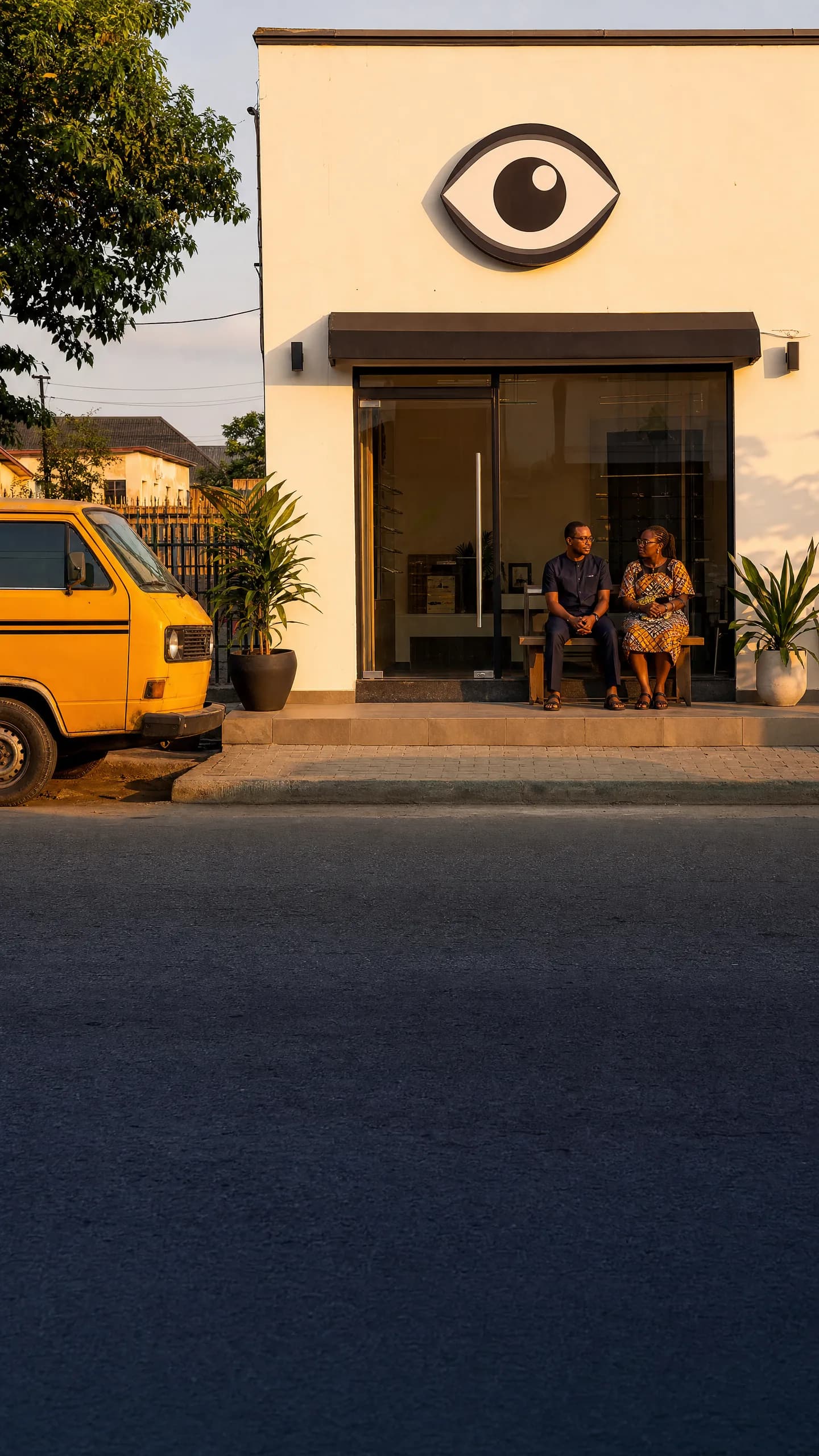 A small eye clinic on a Lagos street at golden hour, just before opening